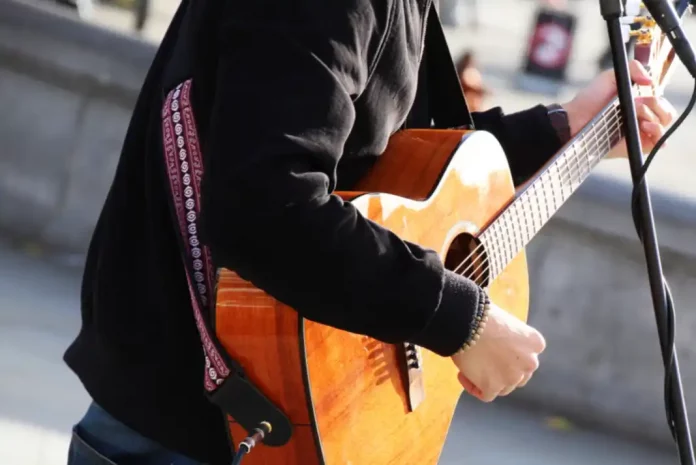 busking Musician playing acoustic guitar outdoors