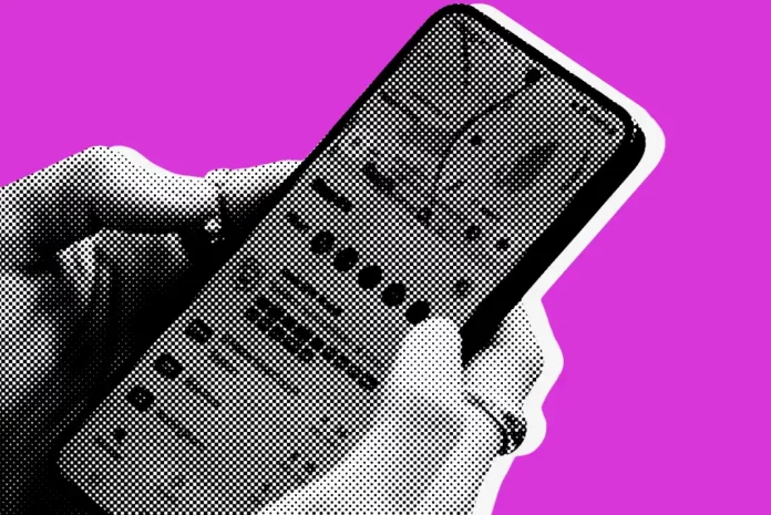 Person holding smartphone on pink background