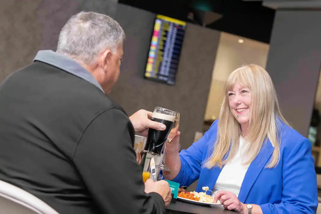 airportpassengers Two people enjoying drinks and food.