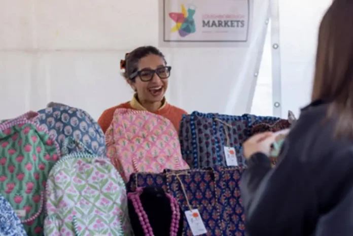 Smiling vendor with colorful bags