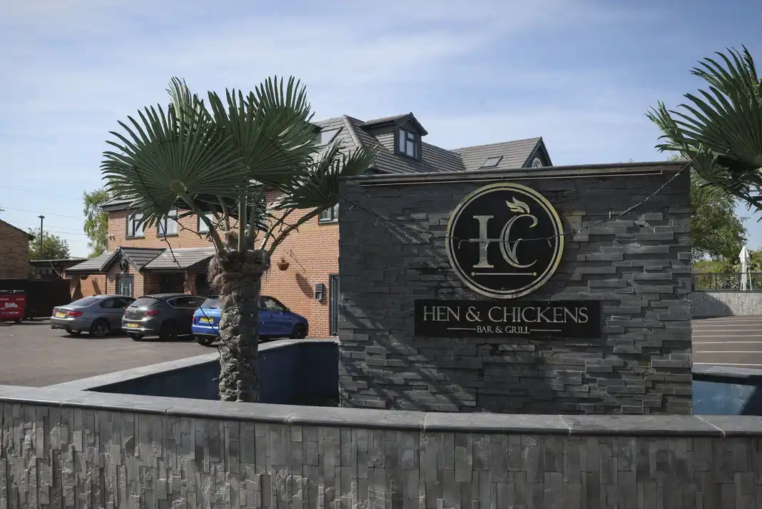 henandchickens Restaurant sign with palm trees