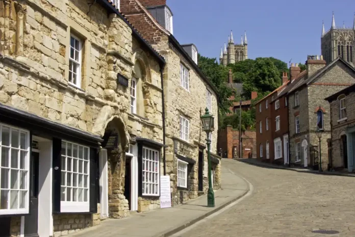 Showing Steep Hill in Lincoln, a charming cobblestone street with buildings