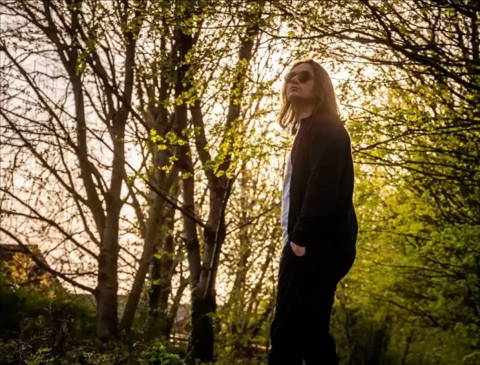 Person standing among trees at sunset
