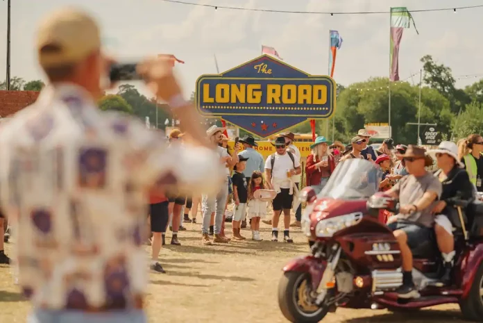 Long Road Festival crowd with motorcycle and signage