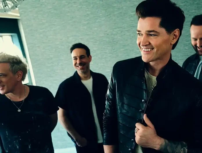 Band members of The Script posing together, smiling.