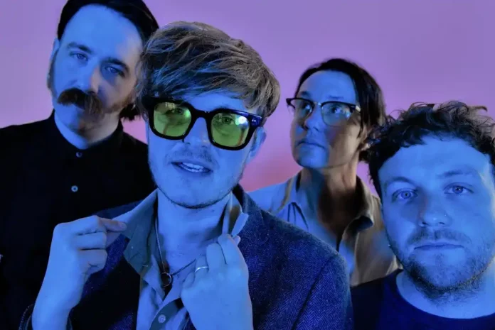 Band posing with colorful lighting.