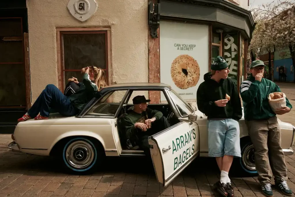 People enjoying bagels by car